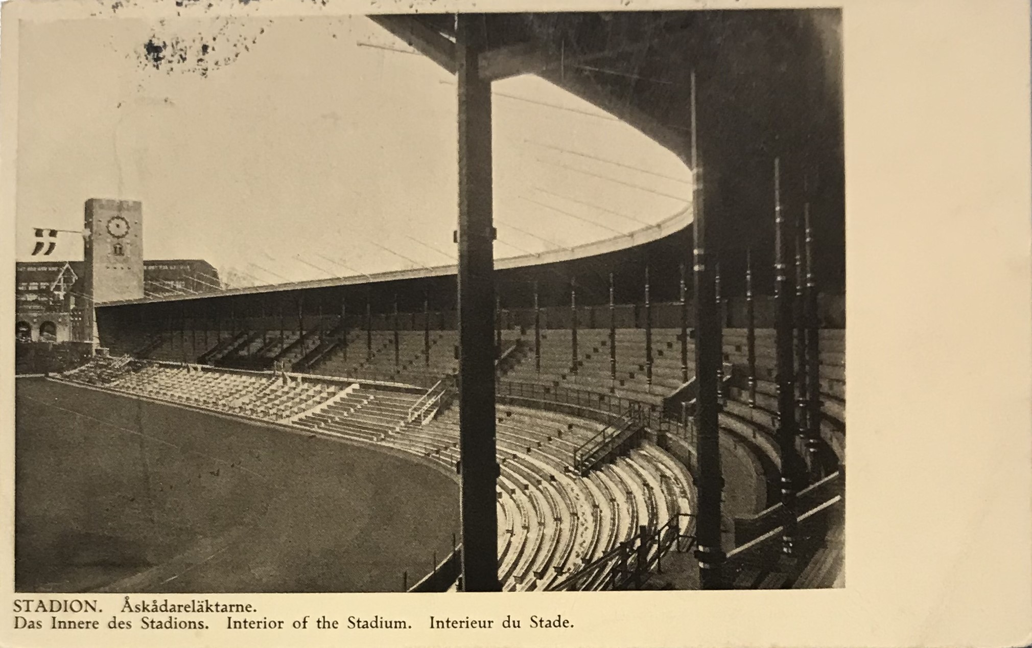 Vykort med ett svartvit fotografi av en tom åskådarläktare på Stockholms stadion