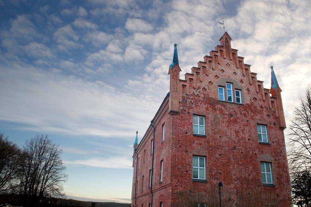 Roggeborgen i Strängnäs fotograferad från sidan, under en blå himmel med lätta moln.