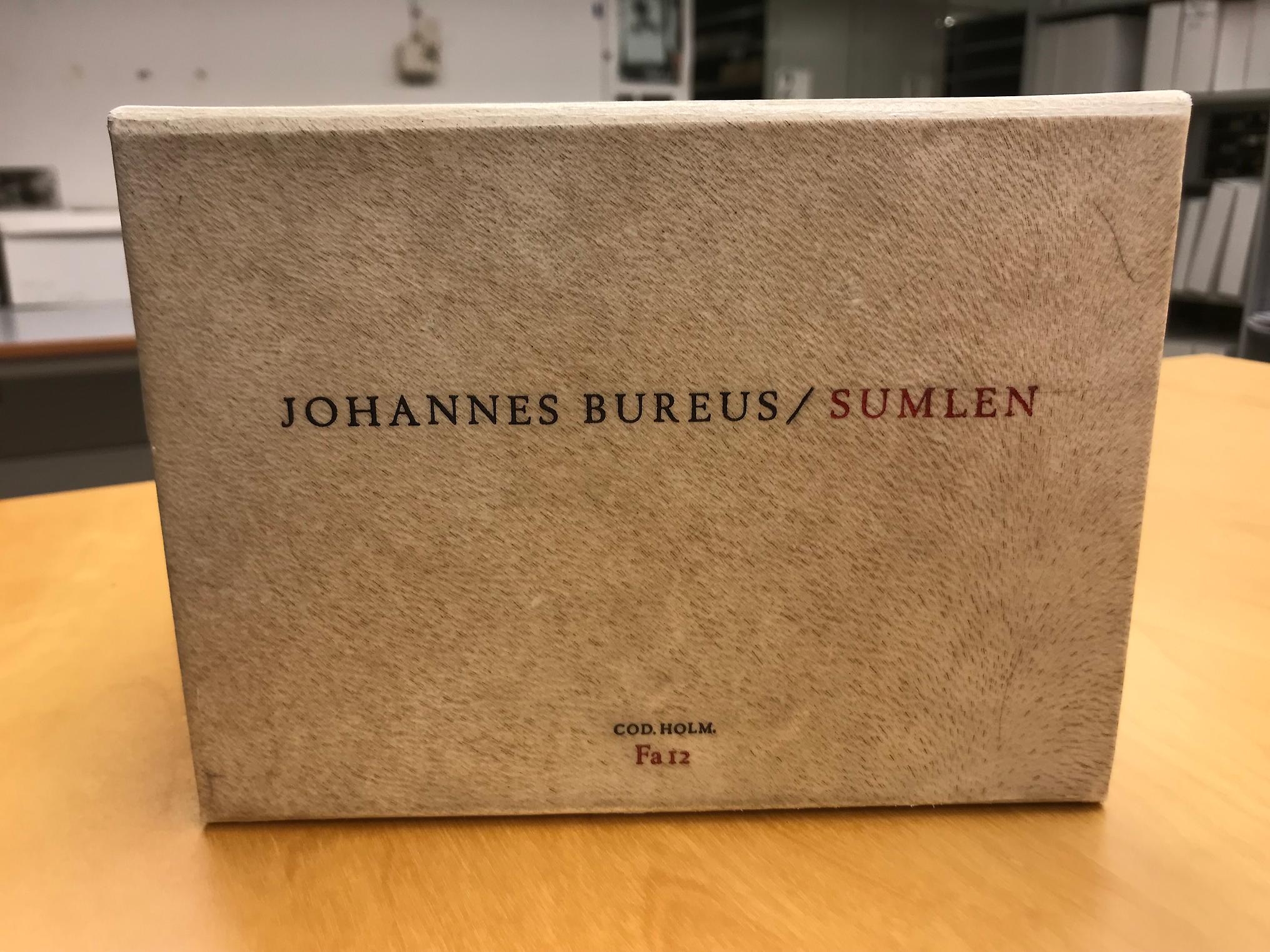 Färgfotografi av en vit låda med texten "Johannes Bureus / Sumlen"